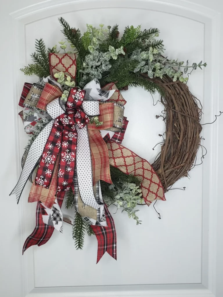 A Holliday Rustic grapevine wreath. Having greenery, and a large bow with plaid and burlap ribbon